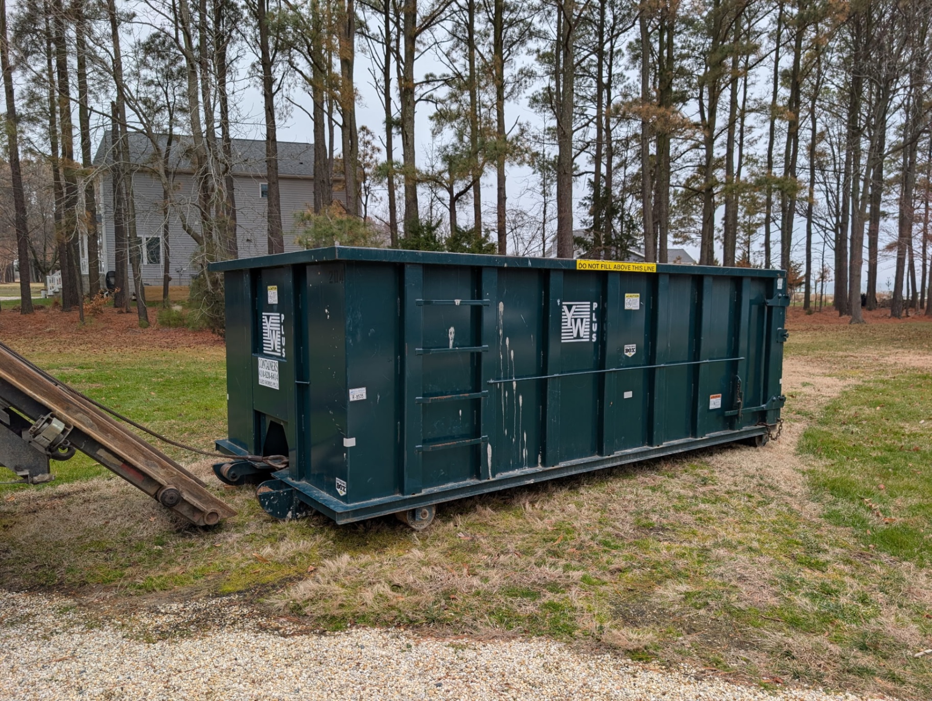 20 yard Yard Works Plus dumpster delivered to a wooded residential property